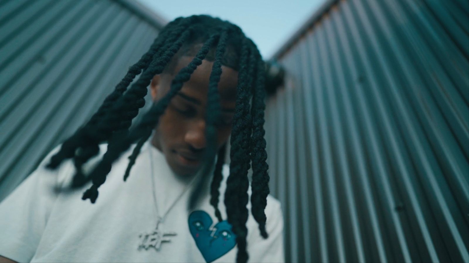 Low-angle close-up, locs falling over his face