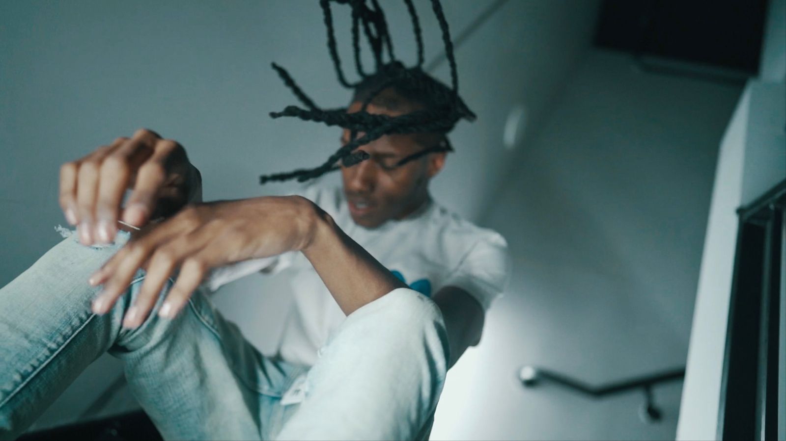 Motion shot on a stairwell, locs flying